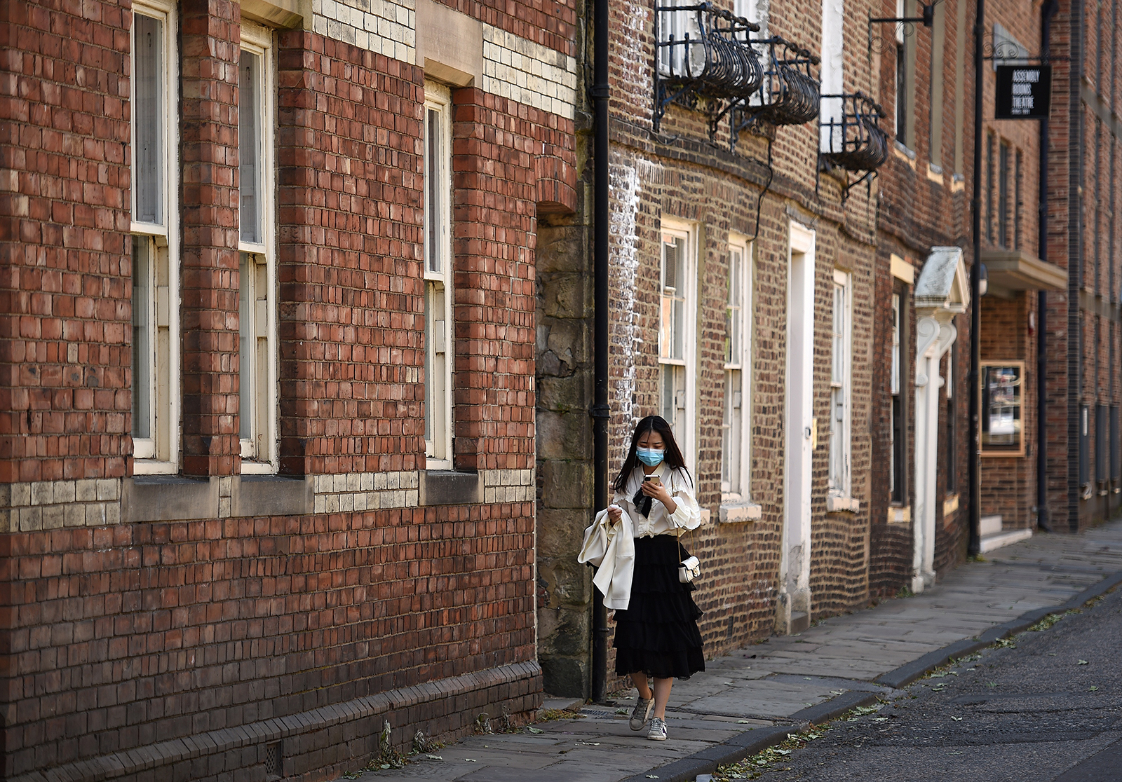 A woman wearing a face mask walks along a street in Durham, northeast of England, on May 25.