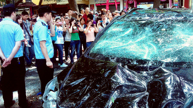 People take photos of a Japanese car damaged during a protest against the nationalization of Japan. The controversial Diaoyu Islands, also known as Senkaku Islands in Japan, in Xi, China on September 15, 2012. 