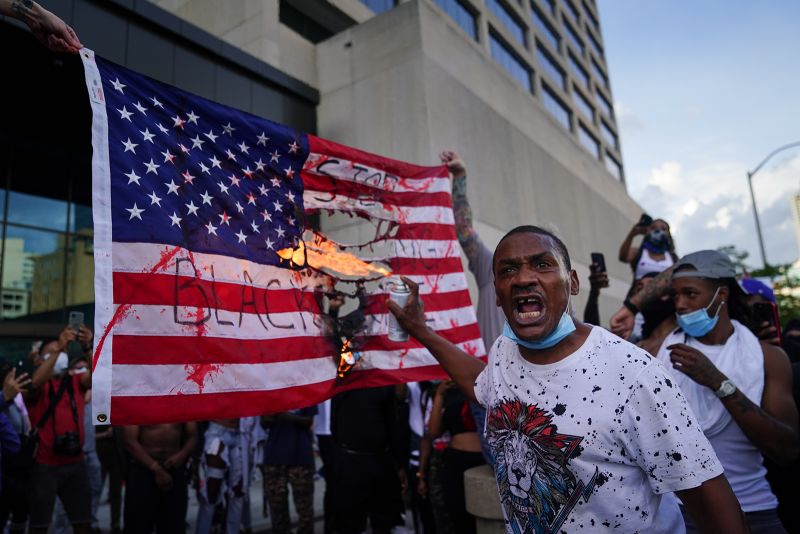 Protesters burn a flag outside the CNN Center on May 29, in Atlanta, Georgia.