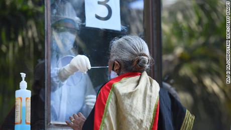 A doctor gathers from India with a stick from a woman to test Covid-19 on June 18 in New Delhi.   