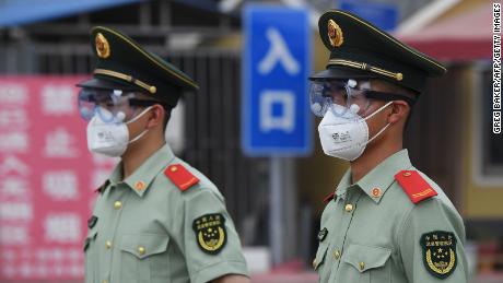 Paramilitary police officers are wearing face masks and goggles as they stand guard at the entrance of the closed Xinfadi market in Beijing on June 13th.