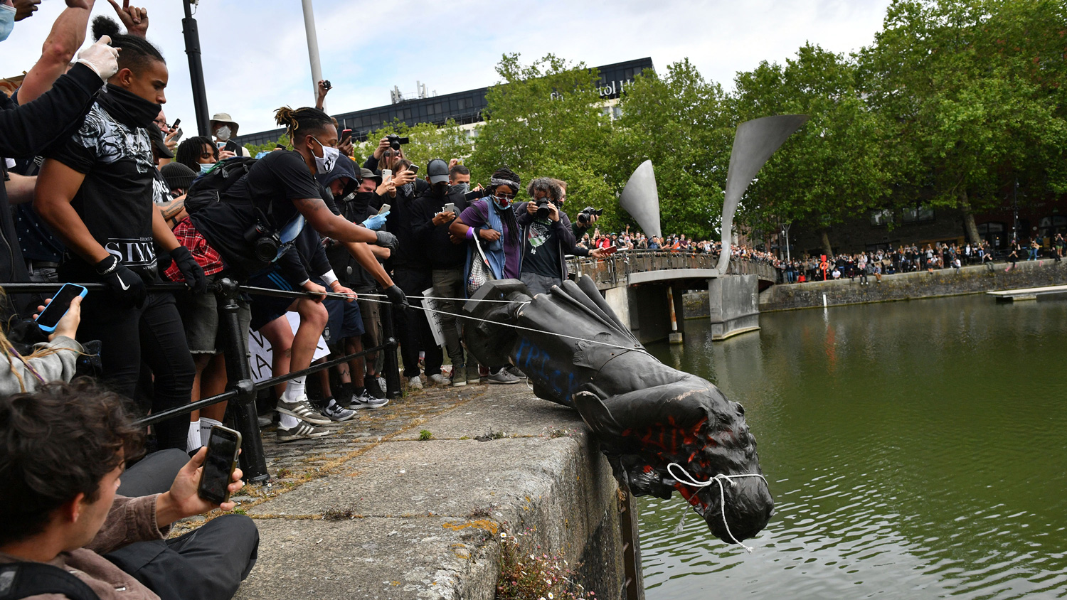 Protesters throw slave merchant Edward Colston statue at the port of Bristol during the Black Lives Matter protest rally in Bristol, England, on 7 June.