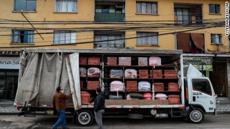 Bergut Funeral Service employees deliver coffins to a funeral store in Santiago, Chile on June 19, 2020. According to its owner, Nicolas Bergerie, coffin production increased by 120%.