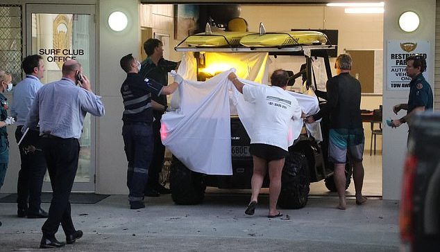 The first attack in the region since 2012 killed a surfer Great White Shark on Net Net Gold Coast beach.  Image: Public and paramedics members covering the man treated behind the beach buggy